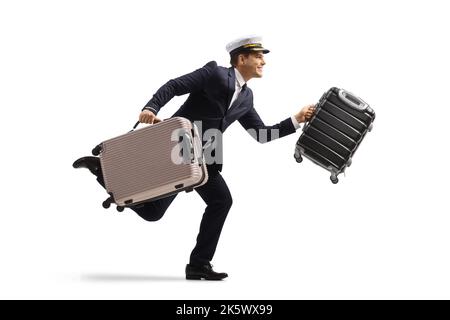 Vue en profil d'un pilote en marche avec des valises isolées sur fond blanc Banque D'Images