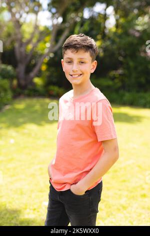 Portrait de jeunes femmes caucasiennes portant un t-shirt orange et debout dans le jardin Banque D'Images