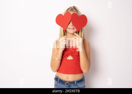 Tellement mignon, charmant et drôle! Portrait de belle douce fille portant des vêtements décontractés, elle rêve au sujet de la confiserie et de la pâtisserie, isolée sur blanc Banque D'Images