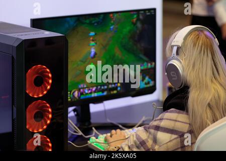 Pologne, Poznan - 09 octobre 2022: Une fille jouant à des jeux d'ordinateur, pendant la foire de jeu vidéo PGA. Banque D'Images