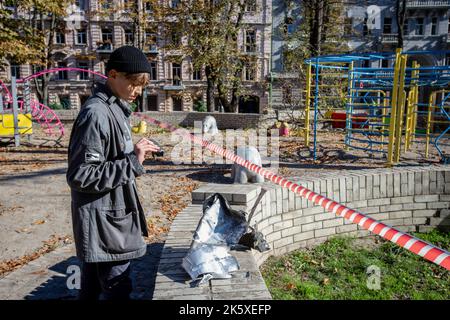 Kiev, Ukraine. 10th octobre 2022. Un garçon regarde un fragment de fusée après une attaque de missile russe dans le centre de Kiev. Des explosions ont été signalées dans plusieurs districts de la capitale ukrainienne, Kiev, sur 10 octobre 2022. Au moins 11 personnes ont perdu la vie et des dizaines de blessés suite à des tirs de roquettes russes ciblant des villes à travers l'Ukraine. (Photo par Oleksii Chumachenko/SOPA Images/Sipa USA) crédit: SIPA USA/Alay Live News Banque D'Images