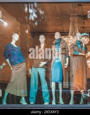 Mannequins féminins dans la fenêtre du magasin avec vêtements demi-saison, reflet de la rue. Shopping Banque D'Images