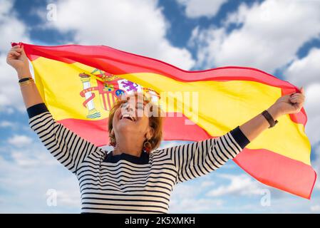 Une dame âgée fière d'être espagnole souriante et agitant le drapeau espagnol. Columbus Day. Columbus Day. Visitez l'Espagne et apprenez l'espagnol Banque D'Images