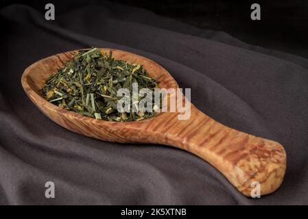 Feuille pleine en vrac vert, thé noir dans une cuillère en bois Banque D'Images
