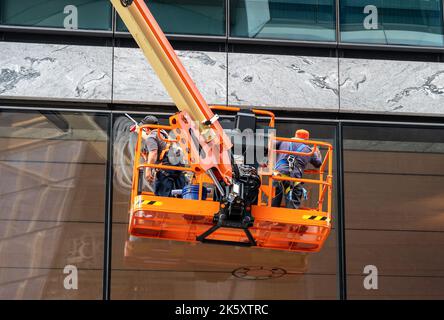 Les nettoyeurs de fenêtres utilisent une tour pour nettoyer les fenêtres d'un gratte-ciel à New York Banque D'Images