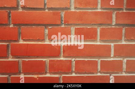 un mur de briques rouges retiré par la façade. Arrière-plan texturé Banque D'Images