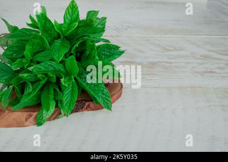 Menthe. Bouquet de feuilles de menthe verte fraîche sur table en bois Banque D'Images