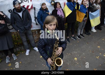 Gdansk, Pologne. 10th octobre 2022. Un garçon joue l'hymne ukrainien sur la trompette. Les Ukrainiens se sont rassemblés devant le consulat russe à Gdansk pour protester contre les bombardements russes de plusieurs villes ukrainiennes. Les Russes ont frappé des infrastructures essentielles et des stations d'approvisionnement en eau, des civils ont été tués et de nombreux blessés. Les manifestants montrent qu'ils soutiennent leur pays et réagissent bruyamment aux attaques russes et aux actes terroristes sur le territoire ukrainien. Crédit : SOPA Images Limited/Alamy Live News Banque D'Images