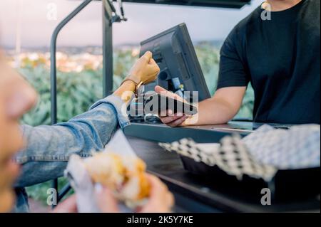 Client anonyme payant la commande contre dame à la cafétéria de rue Banque D'Images