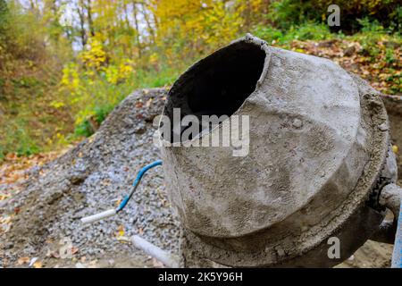 Le mortier de béton est préparé à l'aide d'un mélangeur de béton industriel sur le chantier de construction pour mélanger le mortier de béton. Banque D'Images