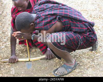 Masai hommes démontrant la technique pour commencer un feu Banque D'Images