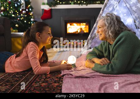 Grand-mère et petite-fille caucasiennes couchée dans la tipi à côté du feu Banque D'Images