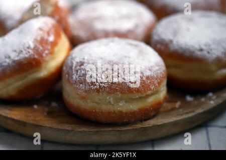 Beignes Berliner en poudre de sucre sur plateau en bois Banque D'Images