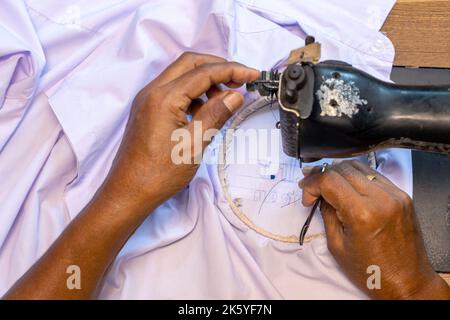 Broder des numéros thaïlandais sur une chemise d'étudiant sur une vieille machine à coudre Banque D'Images