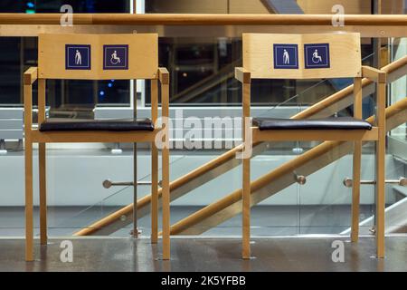 Les chaises portent les logos des personnes handicapées et des personnes âgées dans le couloir Banque D'Images