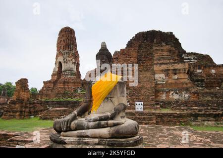 Gros plan de l'image du Bouddha partiellement restauré, devant les ruines du prang central, Wat Mahathe, Parc historique d'Ayutthaya Banque D'Images