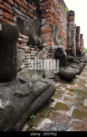 Rangée d'images de Bouddha assis gravement endommagées et vandalisées dans la galerie ou Rabieng Khot, autour de Wat Mahathe, Ayutthaya, Thaïlande Banque D'Images