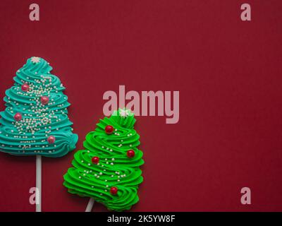 Bonbons verts et bleus sous forme d'arbre de Noël sur fond rouge Banque D'Images