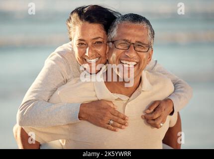 Portrait en gros plan d'un couple de course mixte et affectueux, debout sur la plage et souriant pendant le coucher du soleil à l'extérieur. Couple hispanique montrant l'amour Banque D'Images