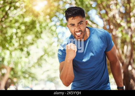 Portrait d'un jeune homme sportif de course mixte qui a l'air motivé et enthousiaste à l'idée de gagner. Homme hispanique célébrant une victoire et exprimant la joie pendant Banque D'Images