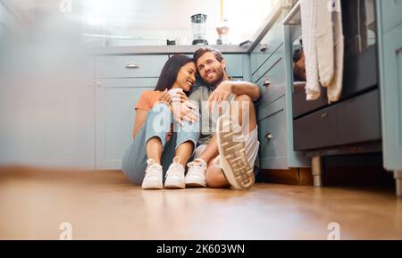 Jeunes heureux couple interracial se liant tout en buvant le café ensemble à la maison. Petit ami caucasien aimant et petite amie de race mixte assis sur le Banque D'Images
