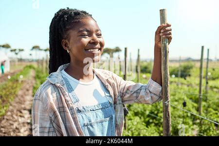 Joyeux fermier debout dans son jardin. Agriculteur afro-américain qui pense à sa ferme. Bonne agriculteur travaillant sur sa ferme. Un ouvrier agricole qui regarde loin. Agriculteur Banque D'Images