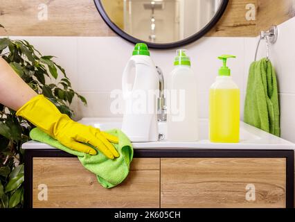 gros plan de la main femelle dans un gant de protection pour contenir une bouteille blanche. Disposition plus claire Banque D'Images