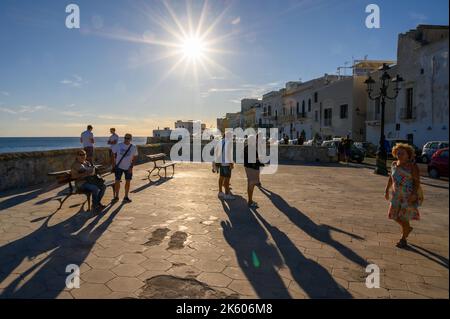 Les gens appréciant le soleil de fin d'après-midi par la Riviera Armando Diaz dans la vieille ville de Gallipoli, Apulia (Puglia), Italie. Banque D'Images