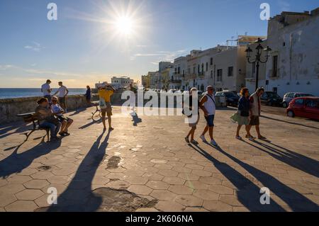 Les gens appréciant le soleil de fin d'après-midi par la Riviera Armando Diaz dans la vieille ville de Gallipoli, Apulia (Puglia), Italie. Banque D'Images