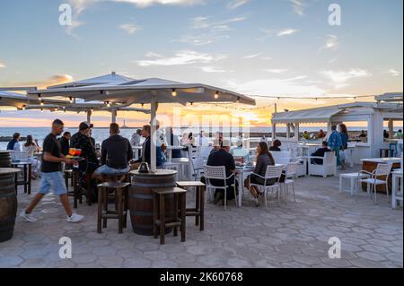 Les personnes qui apprécient la nourriture et les boissons au restaurant en plein air Buena Vista sur le bord de mer médiéval rempart dans la vieille ville de Gallipoli, Apulia (Puglia), Italie. Banque D'Images