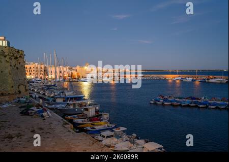 Gallipoli de nuit : vue sur le port des pêcheurs et le port de plaisance des bateaux de loisirs depuis la vieille ville de Gallipoli, Apulia (Puglia), Italie. Banque D'Images