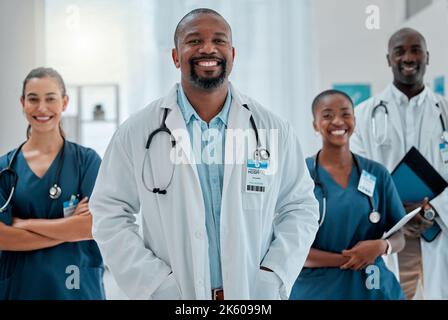 Groupe de médecins heureux et divers se tenant ensemble tout en travaillant dans un hôpital. Contenu professionnels médicaux experts souriant au travail ensemble à un Banque D'Images