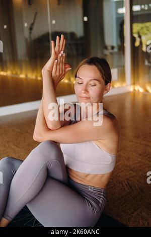 La fille fait du yoga. Une femme en vêtements de sport fait des exercices de yoga dans la salle de gym Banque D'Images