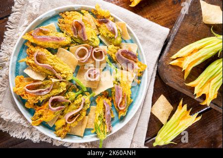 Fleurs de citrouille frites avec anchois et fromage. Cuisine traditionnelle de l'Italie, du sud de l'Italie et de la Sardaigne. Peu de poissons et de fleurs salés. Gros plan Banque D'Images