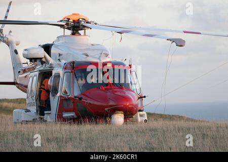 Hélicoptère de garde-côtes au sol suite aux dommages causés au pare-brise lors des opérations sur la falaise à Beachy Head, sur la côte du Sussex au Royaume-Uni Banque D'Images