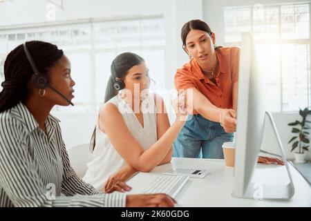 Jeune agent hispanique de télémarketing de centre d'appels formation de nouveaux assistants sur un ordinateur dans un bureau. Solution de dépannage pour les chefs d'équipe avec les stagiaires Banque D'Images