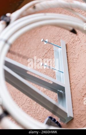 Vis non vissées sur le support métallique du climatiseur mural. Vue rapprochée des pièces de montage de l'unité de climatisation extérieure. Concept d'installation de l'air conditionné Banque D'Images