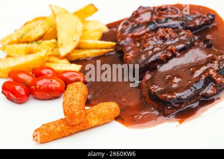 Côtes de porc et doigts de poulet avec sauce barbecue et un côté frites et tomates cerises (sélection) Banque D'Images