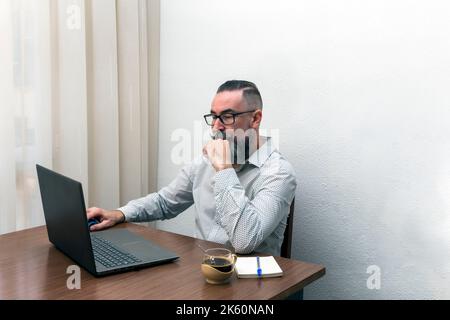 hipster barbu homme travaillant avec un ordinateur portable à la maison Banque D'Images