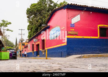 Chapala, Jalisco, Mexique - 10 mai 2021 : façade de bâtiment rouge et bleu sur la rue traditionnelle du village mexicain par la route en pierre de pierre à galets Banque D'Images