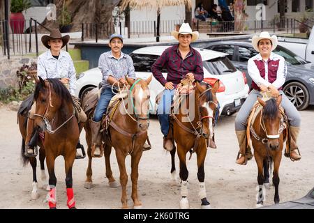 Chapala, Jalisco, Mexique - 10 mai 2021: Quatre Charros mexicains fiers posant sur des chevaux avec un sourire. Cow-boys traditionnels du Mexique debout dans une rangée Banque D'Images