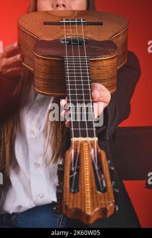 Gros plan Jeune femme jouant un CUATRO, instrument typiquement vénézuélien. Session d'enregistrement, concept de musique et instruments typiques. Banque D'Images