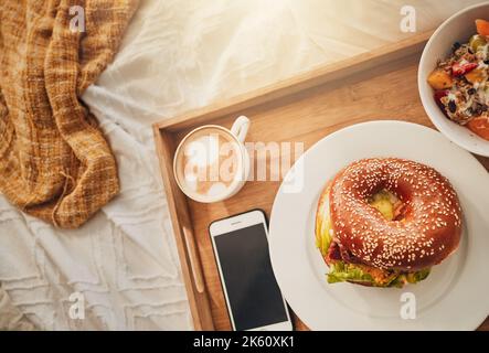 Le cadeau idéal pour la fête des mères. Un plateau d'un petit déjeuner bien équilibré, un bagel, un café et un téléphone portable. Tout le nécessaire pour le petit déjeuner au lit Banque D'Images