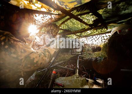 Des soldats en gros plan tirent sur une mitrailleuse 50 Cal machine avec du laiton usé autour d'elle Banque D'Images