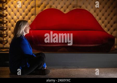 Londres, Royaume-Uni. 11 octobre 2022. Un membre du personnel voit le "mea West Lips sofa", 1938, de Salvador Dali à un aperçu de "objets du désir: Surréalisme et design 1924 – aujourd'hui", une nouvelle exposition au Musée du Design de Kensington. Le spectacle explore la relation entre le surréalisme dans les beaux-arts et le design avec 350 œuvres exposées et se déroule du 14 octobre au 19 février 2023. Credit: Stephen Chung / Alamy Live News Banque D'Images