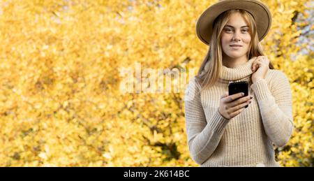 Portrait d'une femme heureuse dans des vêtements décontractés sourires parle promenades communique chat en ligne prend un selfie à l'aide d'une seule technologie de téléphone mobile dans le Banque D'Images