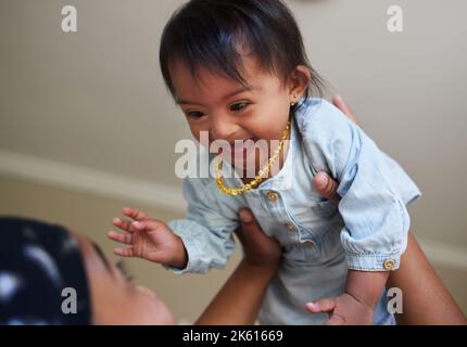 Les enfants, le syndrome de Down et le plaisir avec une fille et la mère jouant ensemble dans leur maison. Famille, enfants et handicap avec une fille adorable ou mignonne Banque D'Images