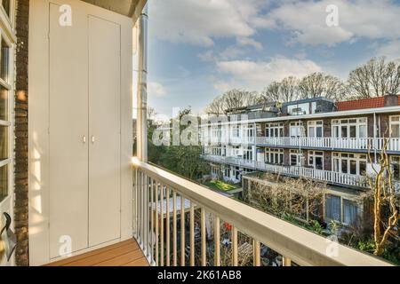 Balcon avec clôture métallique de bâtiment résidentiel situé dans la zone de banlieue avec des plantes vertes contre le ciel bleu le jour d'été Banque D'Images