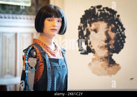 Ai-Da robot pose pour des photos avec un autoportrait au Parlement de Londres avant de faire de l'histoire comme le premier robot à parler à la Chambre des Lords. Le premier discours d’ai-Da robot explorera le rôle de l’apprentissage machine, de la créativité machine et de l’intelligence artificielle dans les industries créatives britanniques. Date de la photo: Mardi 11 octobre 2022. Banque D'Images