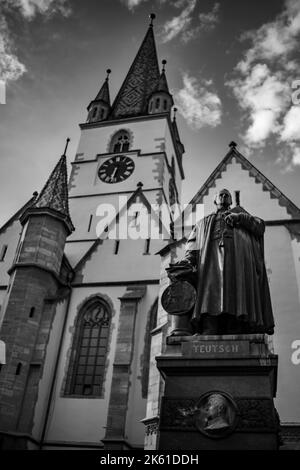 Un cliché en échelle de gris de l'église paroissiale protestante et de la statue de Friedrich Teutsch Banque D'Images